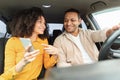 Lady showing application on cellphone to driver guy in car Royalty Free Stock Photo