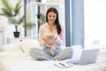 Lady sitting on bed and enjoying chatting with coworkers using smartphone. Royalty Free Stock Photo