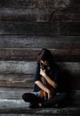 The lady is sitting on grunge surface cement floor,hold violin and bow in her arms,turn face down to violin,vintage and art style