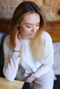 Lady sitting on wooden chair near table and posing for photo. Royalty Free Stock Photo