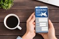 Lady With Smartphone Booking Flight Tickets Sitting At Desk Indoors