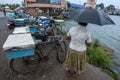 A lady stands adjacent to a row of bicycles and motorbikes in Negombo.