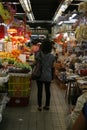 A lady stands with her back to camera in an isle of Sheung Shui market