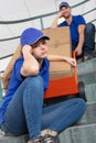 lady struggling to push trolley up stairs loaded with box