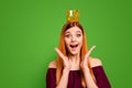 Lady with the surprised face and crown on her head opened her mouth and eyes wide, holding hands near her cheeks Royalty Free Stock Photo
