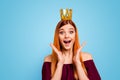 Lady with the surprised face and crown on her head opened her mouth and eyes wide, holding hands near her cheeks Royalty Free Stock Photo