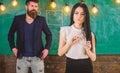 Lady teacher and bearded hipster schoolmaster working together in school. Man with beard and young lady teacher stand in