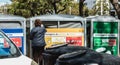 Lady throwing trash into a public garbage bin for plastic and metal in Quarteira, Portugal