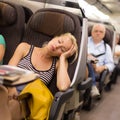 Lady traveling napping on a train.