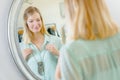 Lady trying on necklace in front mirror