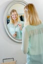 Lady trying on necklace looking in mirror