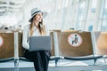 A lady is using her laptop while expecting her flight. Tourist freelancer works and waits for flight in waiting room Royalty Free Stock Photo