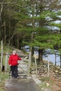 Lady walker at gate on lakeside footpath Cumbria