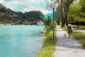 A lady walking her dog on the side of a river