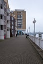 A lady walking beside the lake canary wharf UK