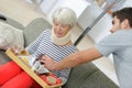 lady wearing neckbrace being help by home help to eat