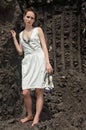 Lady in white sundress inside a deep ground quarry