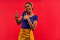 Proud woman in earrings in a blue T-shirt in a yellow skirt shows like gesture. Emotions concept