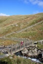 Lady on wooden footbridge over Hayeswater Gill Royalty Free Stock Photo