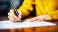 Lady yellow sweater closeup writing signing document on smooth wooden table
