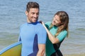 Lady zipping up back mans wetsuit Royalty Free Stock Photo