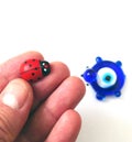 Ladybug and evil eye bead on a white background, close up ladybug, evil eye bead and luck