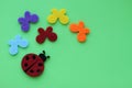 Ladybug and multicolored butterflies on green paper