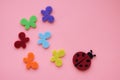 Ladybug and multicolored butterflies on pink paper