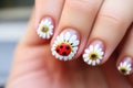 ladybug nail art on fingers wrapped around a daisy stem Royalty Free Stock Photo