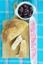 Lagana bread on cutting board, taramosalata on olive dish and kalamon olives on bowl