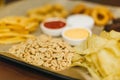 Lager beer and snacks on wooden table. Nuts, chips, peanut, toast, crackers. Appetizer fast food. Craft beer. Beerboard Royalty Free Stock Photo