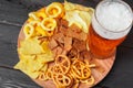 Lager beer and snacks on wooden table. Nuts, chips, pretzel Royalty Free Stock Photo