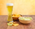 Lager beer and two various potato chips on wooden planks