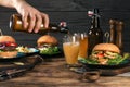 Lager beer on wooden table with a variety of burgers Royalty Free Stock Photo