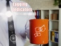 Lagging Indicators phrase. Man with a cup of coffee in the background