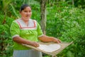 LAGO AGRIO, ECUADOR - NOVEMBER, 17 2016: Woman demonstrates cooking yucca tortillas in an outdoor kitchen in a Siona