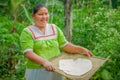 LAGO AGRIO, ECUADOR - NOVEMBER, 17 2016: Woman demonstrates cooking yucca tortillas in an outdoor kitchen in a Siona