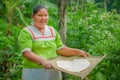 LAGO AGRIO, ECUADOR - NOVEMBER, 17 2016: Woman demonstrates cooking yucca tortillas in an outdoor kitchen in a Siona