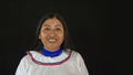 Woman of the Quichua ethnic group of the Ecuadorian Amazon smiling with her traditional dress on a black background