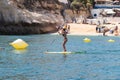 Lagoa, Portugal - July 11, 2020: woman paddle surfing in benagil caves over turquoise waters