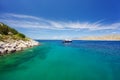 Lagoon in Hydra island, Greece. Crystal clear turquoise water. Luxury yacht with mooring ropes against the rocks