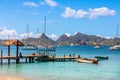 Lagoon with turquoise waters, yachts and boats at Mayreau island pier with Union island in the background, Saint Vincent and the