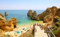 LAGOS, PORTUGAL - JUNE 23, 2018: amazing landscape with people climbing wooden staircase to Praia do Camilo beach near Lagos