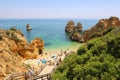 LAGOS, PORTUGAL - JUNE 23, 2018: amazing landscape with people climbing wooden staircase to Praia do Camilo beach near Lagos
