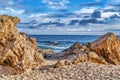 Laguna Beach California shore with rocks and sand against ocean and cloudy sky Royalty Free Stock Photo