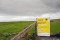 Lahinch / Ireland 08/06/2020: HSE COVID 19 warning poster on a wooden fence, Cows peacefully grazing grass in the background. Grey