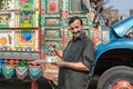 Lahore, Pakistan - October 2019: Man drinking tea near Pakistani colorful truck