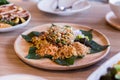 Lahpet is Burmese Tea Leaf Salad served with deep fried garlic, peanut, white sesame, dried shrimp, ginger and roasted coconut