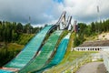 Lahti, Finland - 4 August 2020: Lahti sports centre with three ski jump towers. Sportsman is jumping from the smallest ski jump