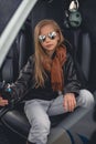 Laid-back tween girl sitting on pilot seat in helicopter